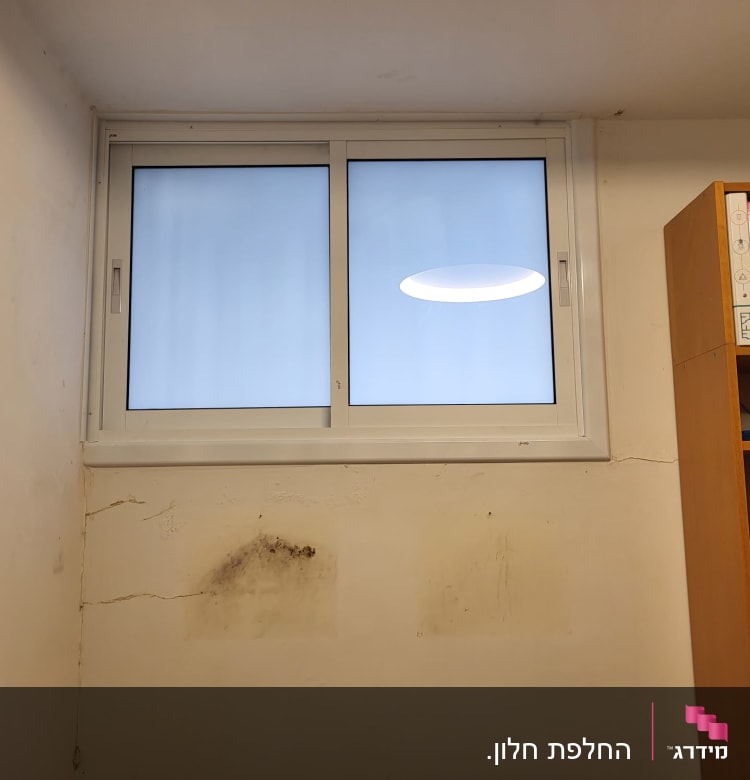 חלון אלומיניום עם מסגרת לבנה על קיר לבן